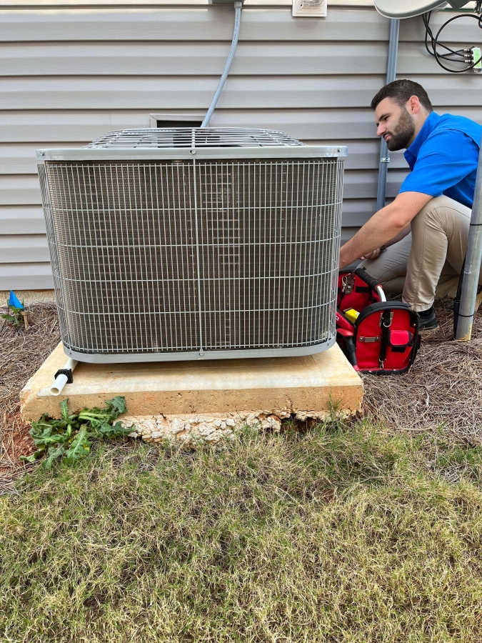 HVAC Technician servicing the outdoor AC unit