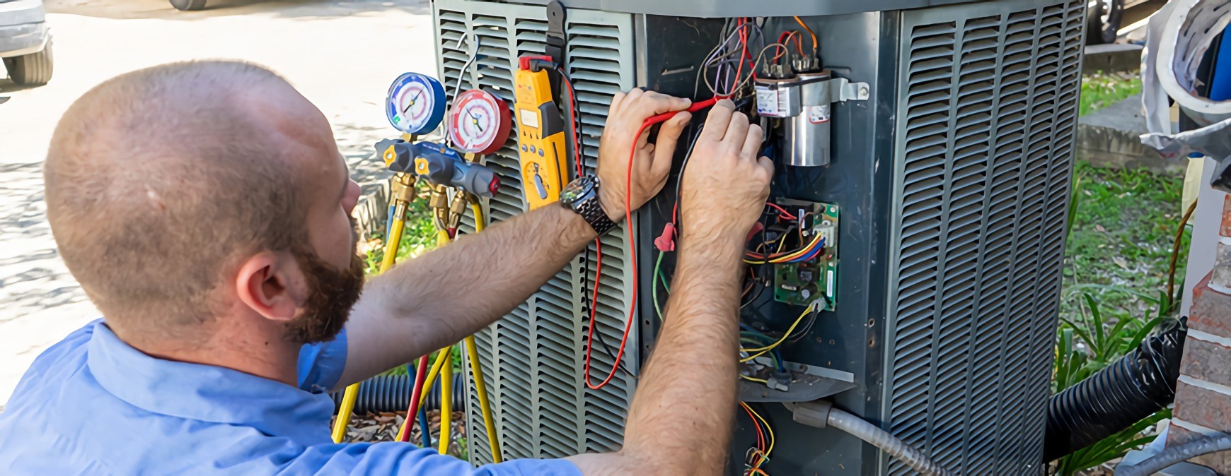 Technician checking outdoor HVAC system